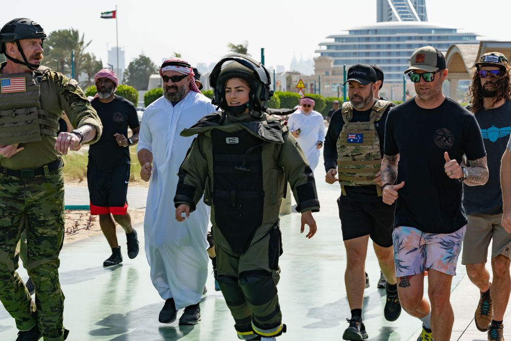 Katie Hernandez running Dubai in the bomb suit with Emirati escort